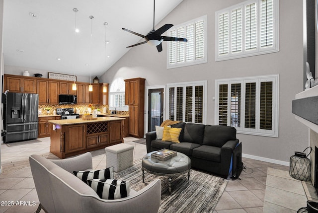 tiled living room featuring ceiling fan, a healthy amount of sunlight, and lofted ceiling