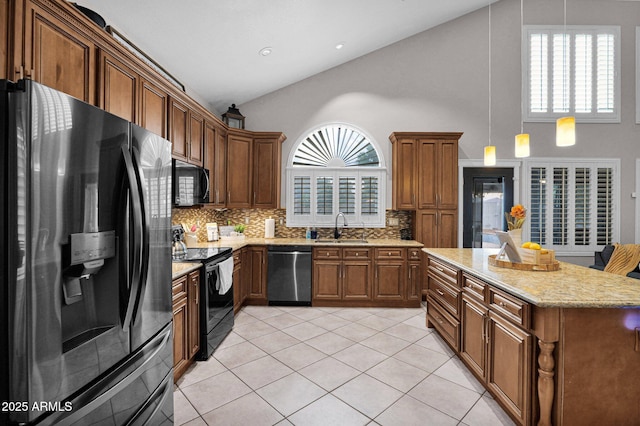 kitchen with light tile patterned flooring, a wealth of natural light, sink, hanging light fixtures, and black appliances