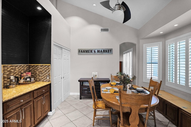 tiled dining room featuring high vaulted ceiling and ceiling fan