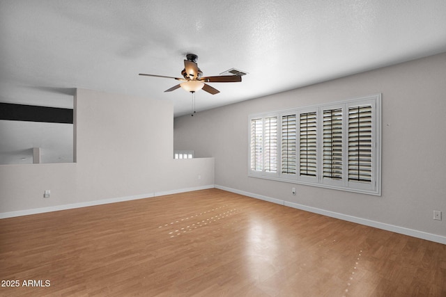 empty room with a textured ceiling, ceiling fan, and light hardwood / wood-style flooring