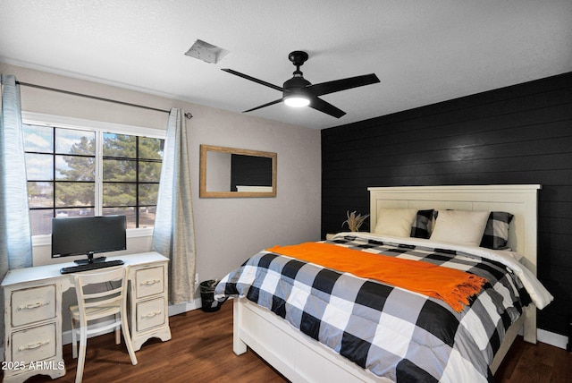 bedroom featuring dark wood-type flooring, ceiling fan, and wood walls