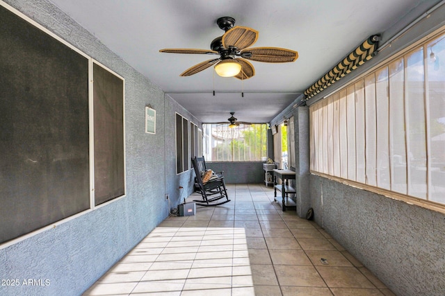 unfurnished sunroom featuring ceiling fan