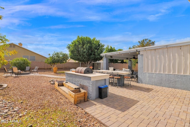 view of patio / terrace with ceiling fan, an outdoor kitchen, and grilling area