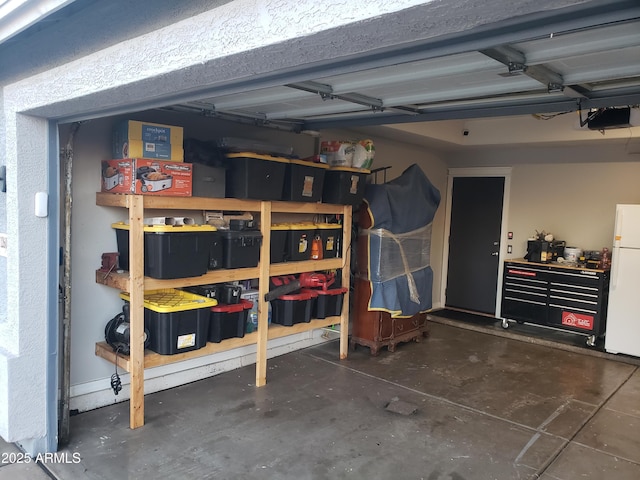 garage featuring white refrigerator and a garage door opener