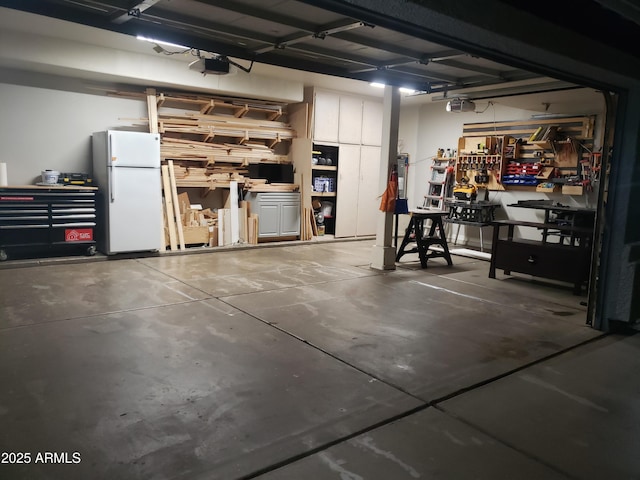 garage featuring a garage door opener, a workshop area, and white refrigerator