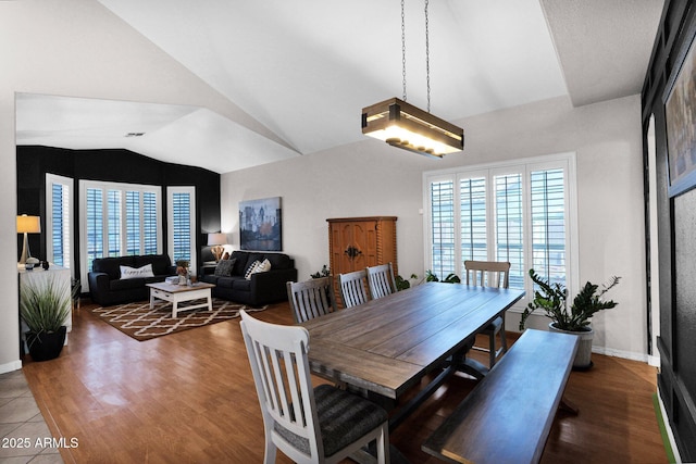 dining room with lofted ceiling and dark hardwood / wood-style floors