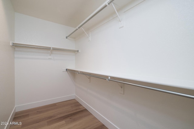 walk in closet with hardwood / wood-style floors