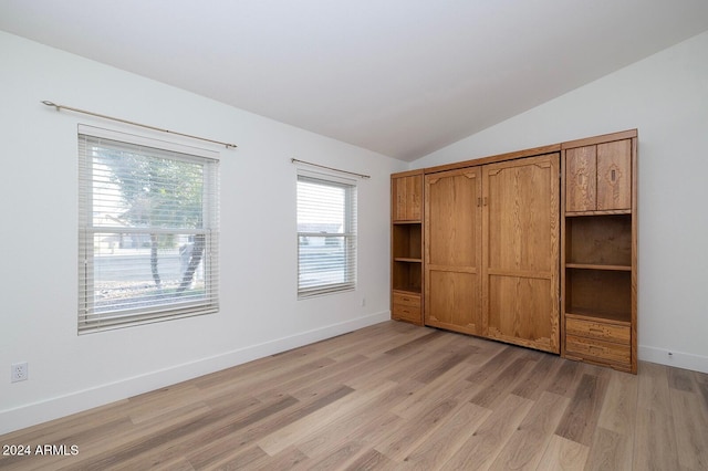 unfurnished bedroom featuring light hardwood / wood-style flooring and lofted ceiling