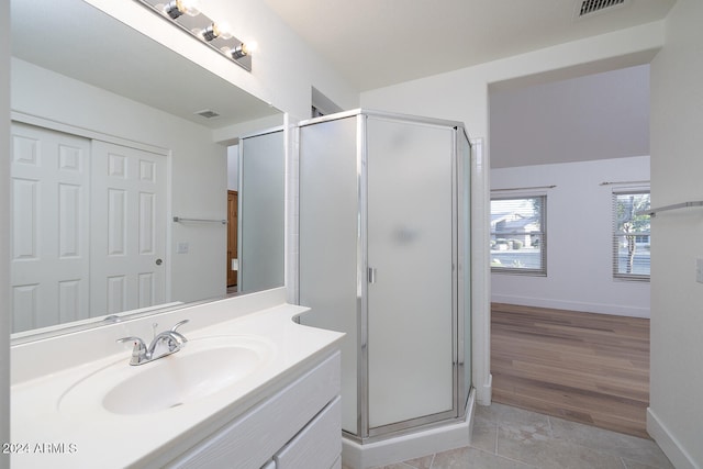 bathroom with vanity, a shower with shower door, and wood-type flooring