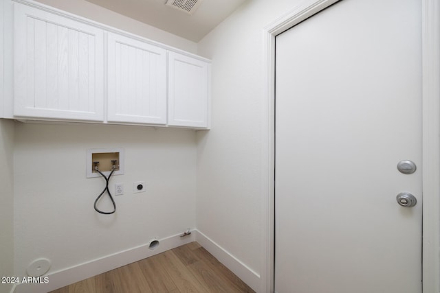 laundry area with cabinets, washer hookup, hookup for an electric dryer, gas dryer hookup, and light wood-type flooring