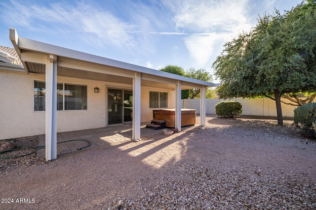 back of house with a patio and a hot tub