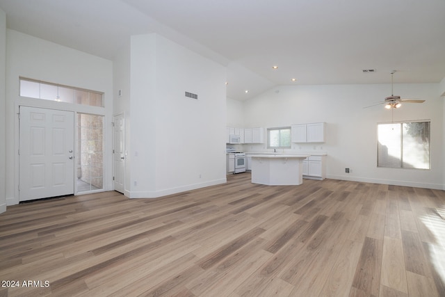 unfurnished living room featuring high vaulted ceiling, light hardwood / wood-style flooring, and ceiling fan