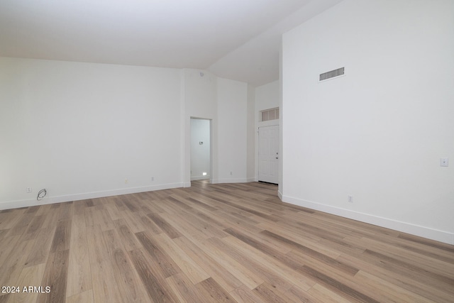 unfurnished room featuring high vaulted ceiling and light wood-type flooring