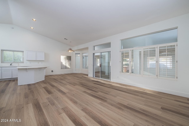 unfurnished living room featuring ceiling fan, light hardwood / wood-style flooring, lofted ceiling, and sink