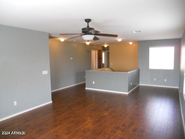 empty room featuring ceiling fan and dark wood-type flooring