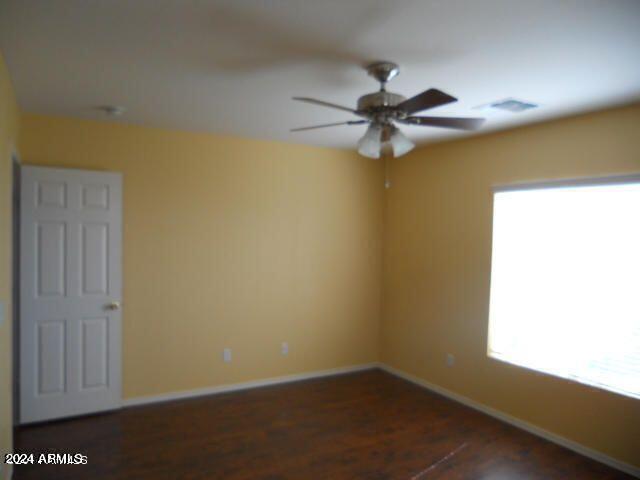 empty room featuring dark hardwood / wood-style flooring and ceiling fan