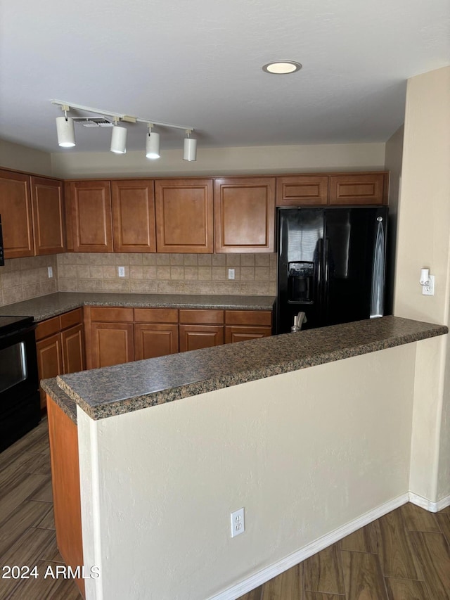 kitchen with backsplash, black appliances, and dark hardwood / wood-style flooring