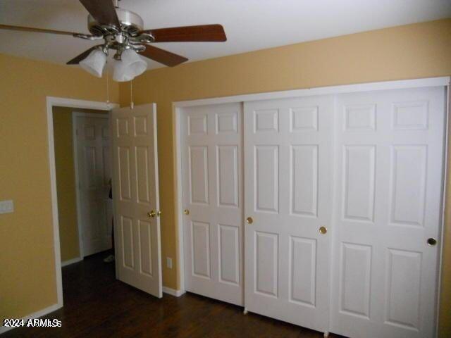 unfurnished bedroom featuring dark hardwood / wood-style flooring and ceiling fan