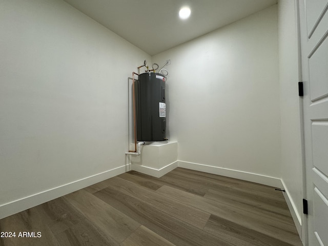 interior space with electric water heater and hardwood / wood-style flooring