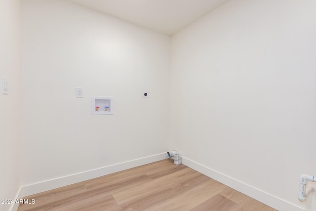 clothes washing area with hookup for an electric dryer, washer hookup, and wood-type flooring