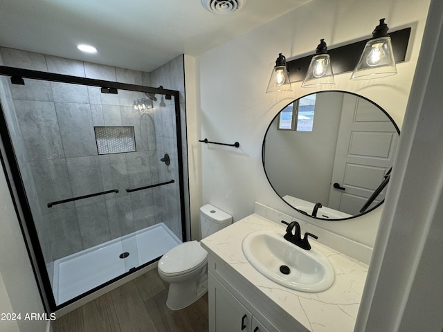 bathroom featuring vanity, toilet, walk in shower, and wood-type flooring