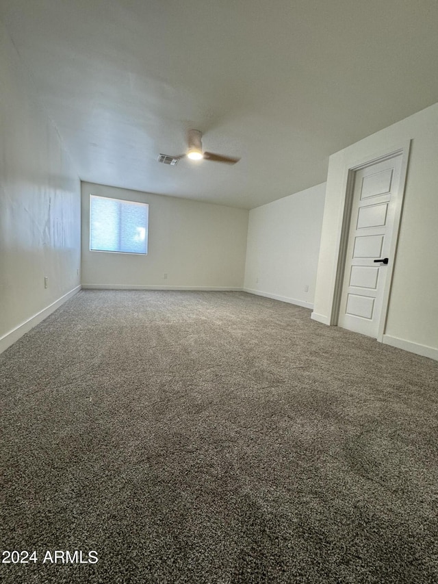 carpeted spare room featuring ceiling fan