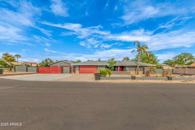single story home with driveway, a gate, an attached garage, and a fenced front yard