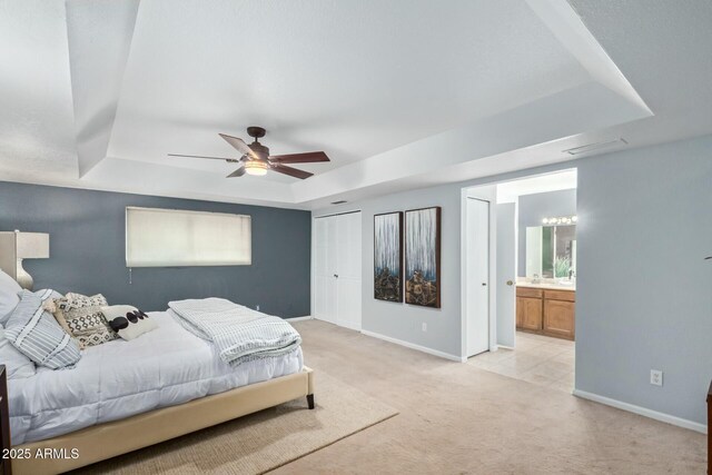 18585 N 70th Ave, Glendale, AZ 85308 - bedroom featuring visible vents, baseboards, a raised ceiling, connected bathroom, and light colored carpet