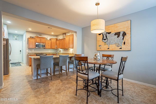 dining area featuring sink and light tile patterned floors