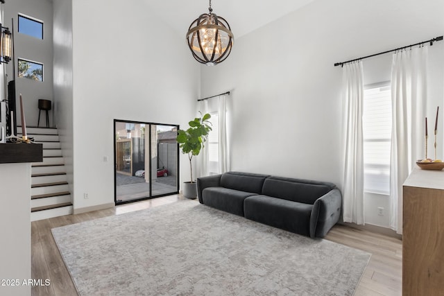 2533 W Novak Way, Phoenix, AZ 85041 - living area featuring a chandelier, a towering ceiling, healthy amount of natural light, and light wood-type flooring