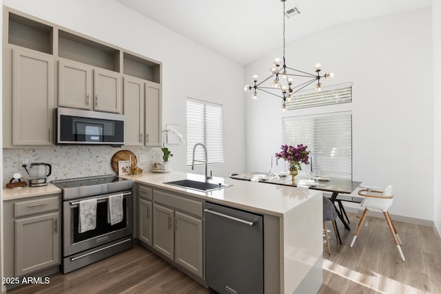 2533 W Novak Way, Phoenix, AZ 85041 - kitchen with appliances with stainless steel finishes, a sink, a peninsula, a chandelier, and backsplash