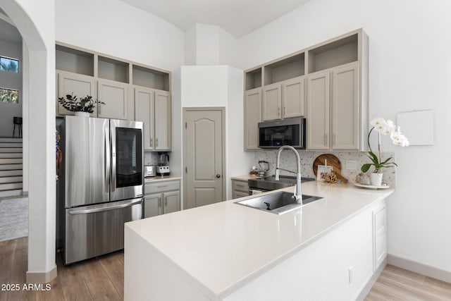 2533 W Novak Way, Phoenix, AZ 85041 - kitchen featuring stainless steel appliances, backsplash, a peninsula, and light wood finished floors