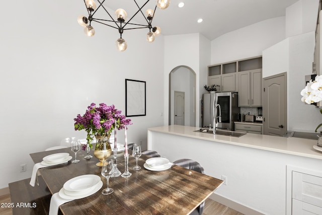 2533 W Novak Way, Phoenix, AZ 85041 - dining room with arched walkways, wood finished floors, a chandelier, a towering ceiling, and recessed lighting