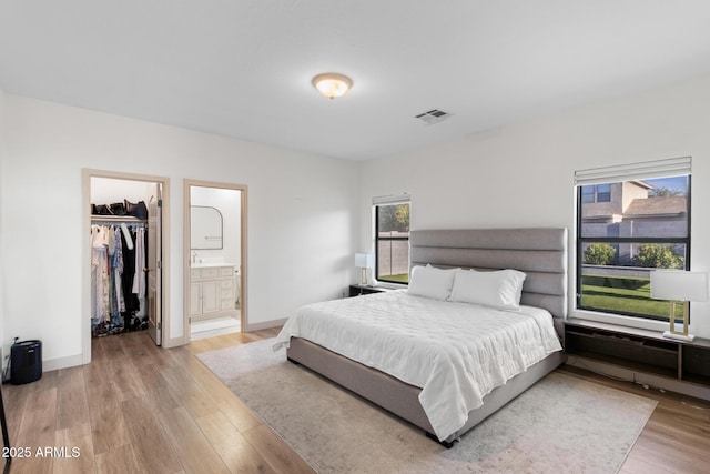 2533 W Novak Way, Phoenix, AZ 85041 - bedroom with wood finished floors, a spacious closet, connected bathroom, a closet, and baseboards