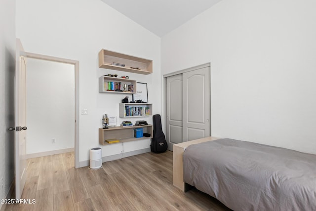 2533 W Novak Way, Phoenix, AZ 85041 - bedroom featuring wood finished floors, high vaulted ceiling, a closet, and baseboards
