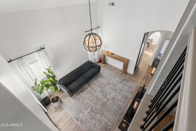 2533 W Novak Way, Phoenix, AZ 85041 - living room with arched walkways, wood finished floors, a chandelier, a towering ceiling, and baseboards