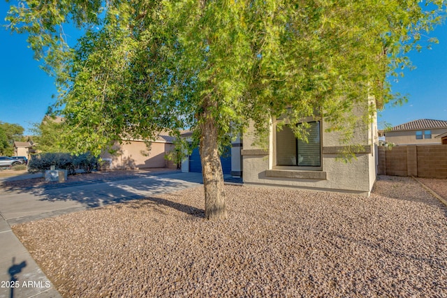 2533 W Novak Way, Phoenix, AZ 85041 - view of property hidden behind natural elements featuring stucco siding, fence, concrete driveway, and a garage