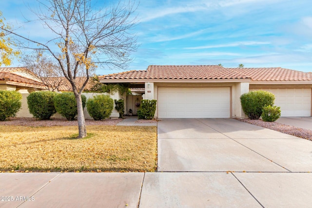 mediterranean / spanish-style home with a garage and a front lawn