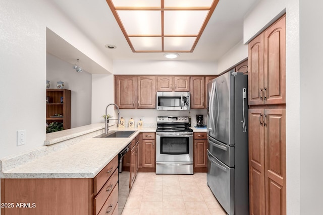 kitchen featuring kitchen peninsula, sink, light stone counters, light tile patterned flooring, and stainless steel appliances