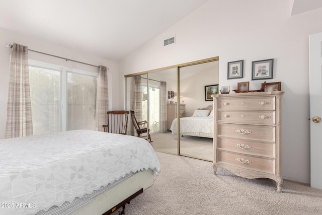 bedroom with light colored carpet, multiple windows, a closet, and vaulted ceiling