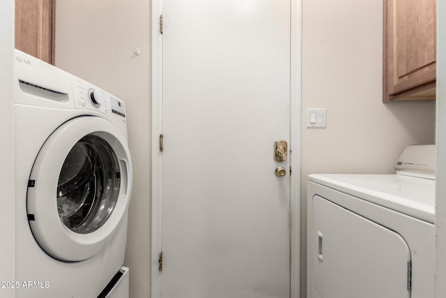 washroom with cabinets and washer and dryer