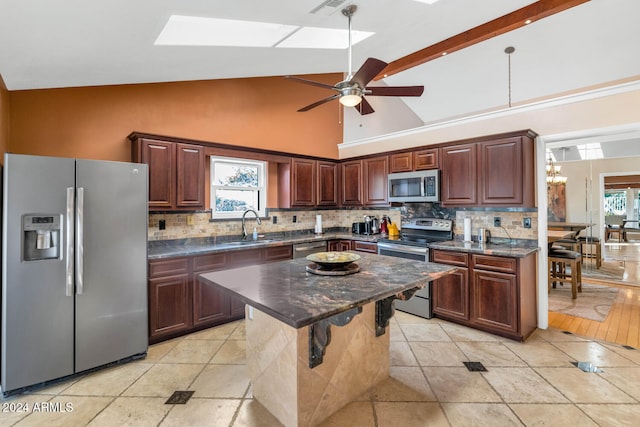 kitchen with a center island, high vaulted ceiling, ceiling fan with notable chandelier, sink, and stainless steel appliances