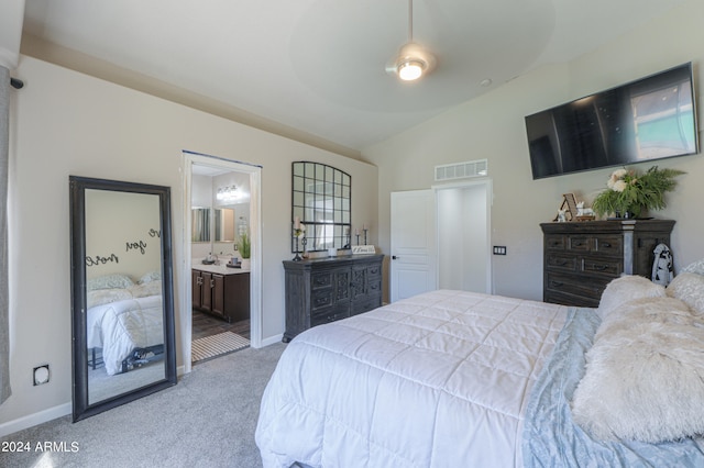 bedroom featuring ceiling fan, light colored carpet, connected bathroom, and vaulted ceiling