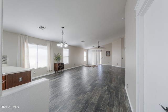 unfurnished living room featuring ceiling fan with notable chandelier and dark hardwood / wood-style flooring