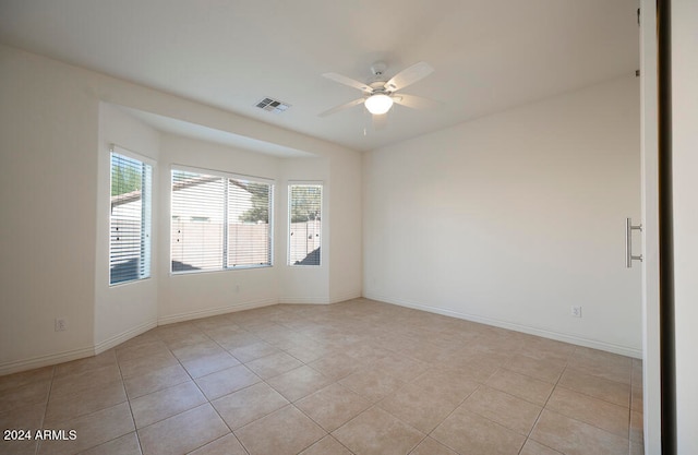 unfurnished room with light tile patterned floors and ceiling fan