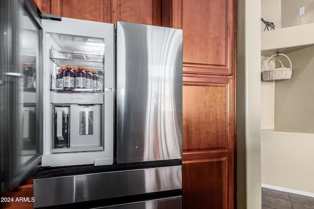 kitchen featuring stainless steel refrigerator and dark tile patterned flooring