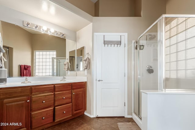 bathroom featuring tile patterned flooring, vanity, and a shower with shower door