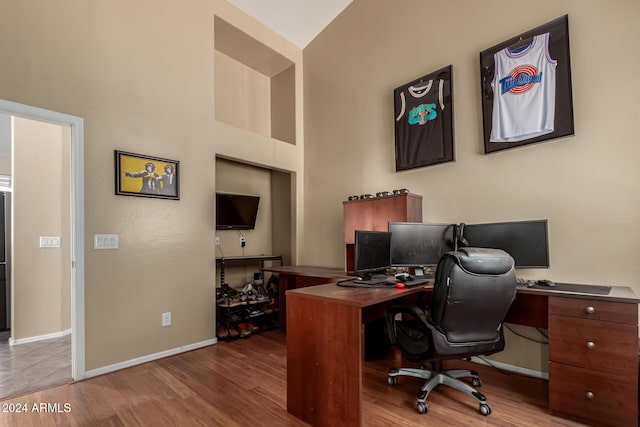 home office featuring lofted ceiling and hardwood / wood-style flooring