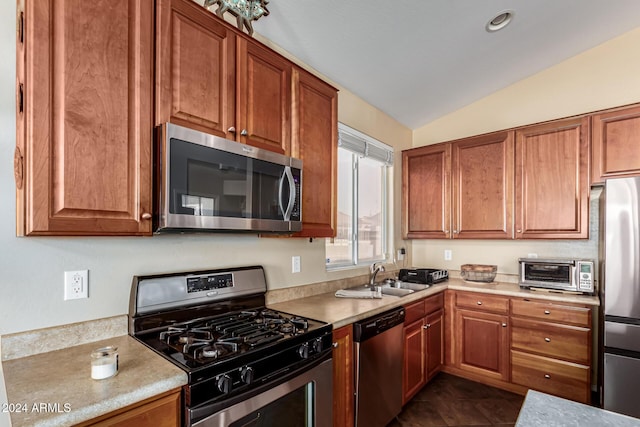 kitchen featuring dark tile patterned flooring, sink, lofted ceiling, and stainless steel appliances