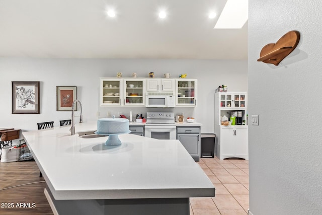 7031 S 32nd Pl, Phoenix, AZ 85042 - kitchen featuring white appliances, light countertops, a sink, glass insert cabinets, and light tile patterned floors